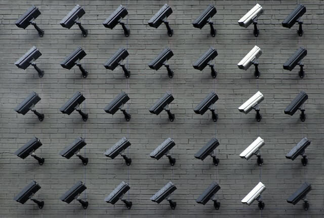Assorted security cameras mounted on a wall.